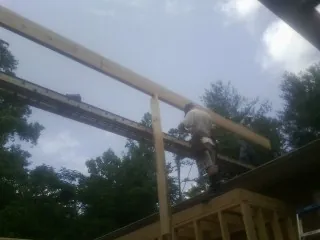 Carpenter setting a ridge beam over a new addition frame — Ice Dam Removal by Roofing Brothers in Lake Hiawatha