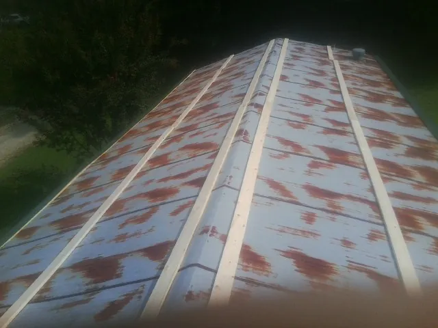 Rusted metal roof panels with new wood purlins before replacement — Storm Damage Roof Repair in Lake Hiawatha by Roofing Brothers
